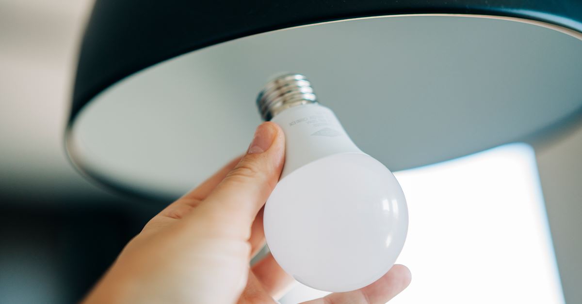 hand screwing in a lightbulb